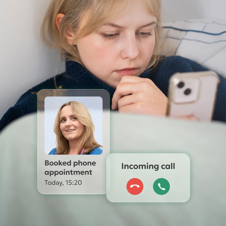 A woman lying in bed, looking at her phone screen